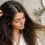 زن با پوست سر چرب و ساقه خشک در حال بررسی ریشه و نوک مو
